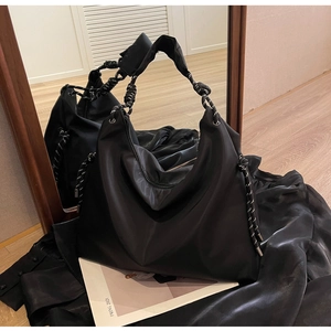 Detail of black large capacity hobo bag with unique woven black and white rope handle