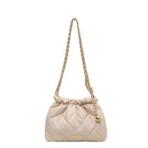 Quilted cream crossbody bucket bag with gold chain and sphere charm on white background