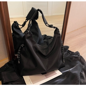 Detail of black large capacity nylon hobo bag with thick braided rope handle and drawstring