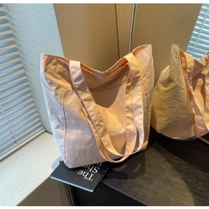 Macro shot of peach pink nylon tote bag texture and convenient side pocket detail