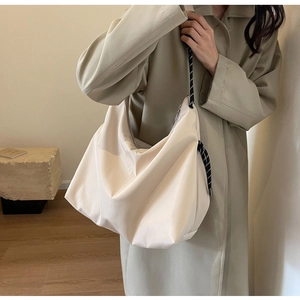 Detail of off-white Oxford tote bag featuring stylish black and white braided rope straps