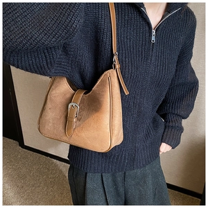 Dettaglio della borsa hobo in pelle scamosciata marrone caramello con tracolla regolabile e fibbia