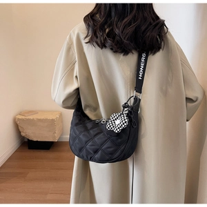 Détail du sac lune en nylon matelassé noir avec bandoulière à logo et breloque fleurie