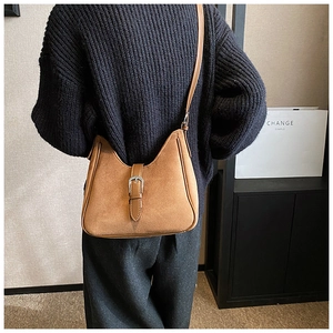 Dettaglio borsa a mezzaluna marrone opaco vintage su modella con maglia blu
