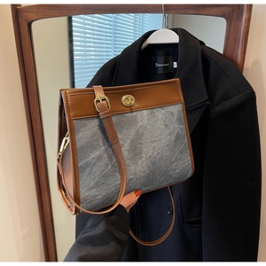 Detail view of large brown vintage tote bag with gold twist lock and adjustable strap