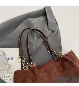 Détails du sac cabas en daim marron avec poignées en cuir et attaches en chaîne dorée