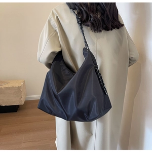 Detail of black large-capacity Hobo bag featuring a stylish woven knot shoulder strap