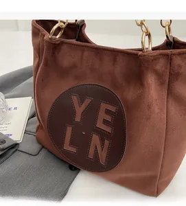 Détail du sac cabas vintage en daim marron avec chaîne dorée et empiècement cuir