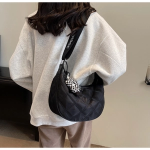 Dettaglio borsa hobo trapuntata nera con tracolla logo e ciondolo a cuore a scacchi