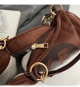 Détail de la fermeture dorée et du logo VE sur le sac cabas vintage en daim marron