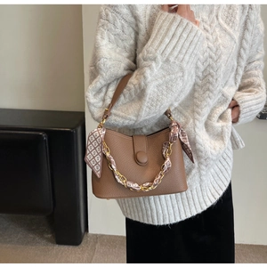 Brown lychee leather handbag with gold chain and printed silk scarf on a model