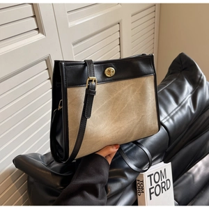 Detail of canvas and leather tote bag featuring gold twist lock and adjustable shoulder strap