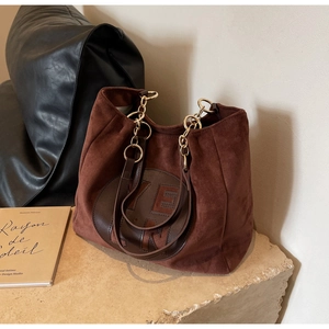 Détail du sac cabas vintage en daim marron avec logo FERN et chaîne en métal doré