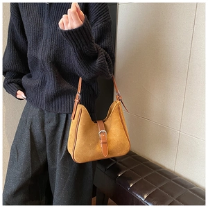 Dettaglio della borsa a tracolla vintage giallo senape con cinturino in pelle marrone