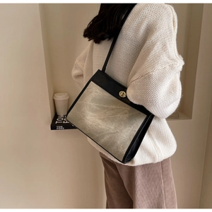 Detail of vintage canvas shoulder bag with black leather trim and gold metal lock