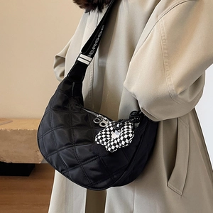 Sac croissant en nylon matelassé noir avec bandoulière large et breloque fleur