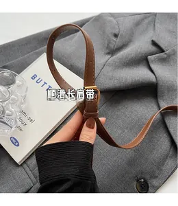 Close-up of adjustable brown leather strap with metal buckle for versatile styling