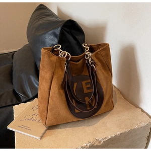 Détails du sac fourre-tout en daim marron avec bandoulière chaîne et écusson en cuir