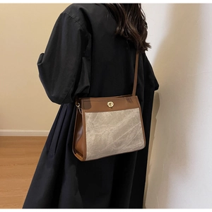 Detail of vintage patchwork crossbody bag featuring stone texture fabric and gold buckle