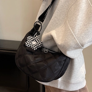 Sac croissant en nylon noir matelassé avec charme fleur en damier et large bandoulière