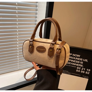 Detail view of the beige frosted suede Boston bag with brown leather trim and handles