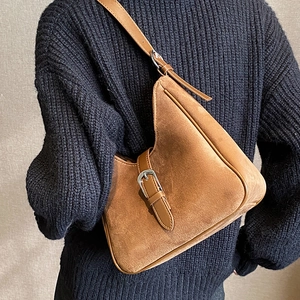 Borsa a secchiello sottospalla in pelle scamosciata marrone indossata su maglione blu