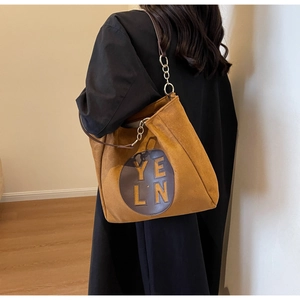 Détail d'un grand sac cabas en suédine marron avec empiècement en cuir et chaîne