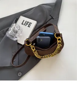 Macro view showing internal storage space for two phones in a retro brown saddle bag