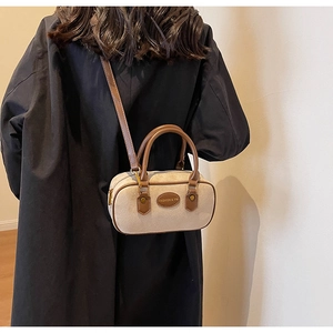 Detail of beige suede mini boston bag with brown leather handles and brand logo