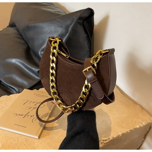 Detailed view of brown suede hobo bag with gold chain and smooth leather trim
