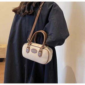 Detail of beige frosted Boston bag featuring leather trim and fashion logo accent