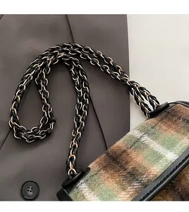 Detailed close-up of retro plaid fabric texture and premium leather chain strap on shoulder bag