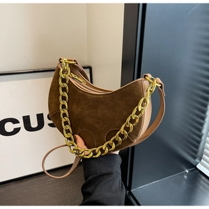 Detail of brown suede half-moon bag with gold chain strap and smooth zipper closure