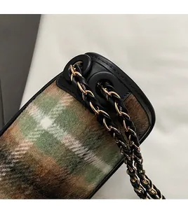 Close-up of retro plaid fabric with precision stitching and leather trim details