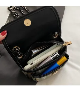 Interior view showing the large capacity of the black chain bag with phone and cosmetics