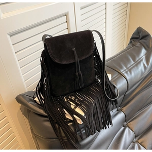 Détail du sac bandoulière en daim noir avec de longues franges et des pompons bohèmes