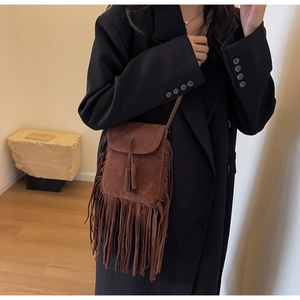 Détail du sac bandoulière en daim marron foncé avec de longues franges et texture mate