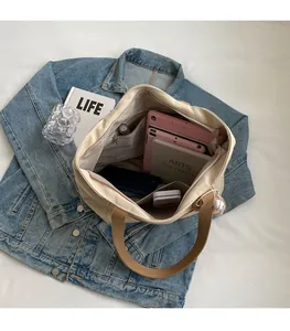 Detailed interior of a beige nylon tote bag showing spacious compartments and pockets