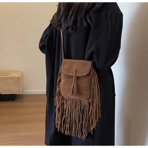 Vue détaillée d'un sac seau marron en daim à franges porté par un mannequin pour le style