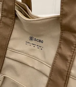 Dettaglio delle cuciture rinforzate e delle trame a contrasto sulla borsa tote in tela