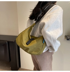 Detail showing an olive green crescent hobo bag with a black wide adjustable strap