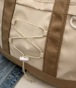 Dettaglio della borsa tote in nylon con coulisse elastica e trama del tessuto resistente