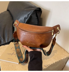 Detail of vintage brown leather belt bag with colorful geometric woven strap and gold hardware