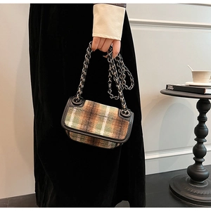 Detail of a vintage plaid crossbody bag with chain strap in a lifestyle setting