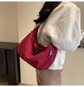 Burgundy nylon hobo bag shown from a side-back view with stylish woven rope detail