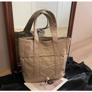 Dettaglio della borsa tote in nylon kaki con coulisse frontale e riflesso a specchio