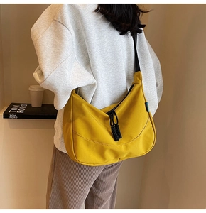 Detail of mustard yellow crescent canvas bag with adjustable black nylon strap and drawstrings