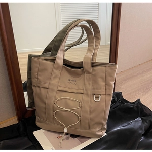 Dettaglio allo specchio di borse tote in nylon color kaki e verde scuro con coulisse