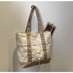 Dettaglio della grande borsa tote in nylon con coulisse e design a blocchi di colore
