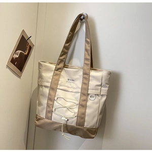 Dettaglio della borsa tote in nylon con logo SCBG, coulisse e gancio ad anello a D